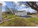 Backyard view with a shed, a partial gravel driveway, and a tree providing shade on a sunny day at 2501 Reformers Ave, Indianapolis, IN 46203