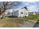 View of the backyard featuring a grassy lawn, a metal fence, and a single story home with white siding at 2501 Reformers Ave, Indianapolis, IN 46203