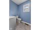 Bathroom with a white toilet, vanity, blue walls and window for great natural light at 2501 Reformers Ave, Indianapolis, IN 46203