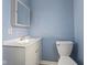 This bathroom features a gray vanity, toilet, blue walls, and tile flooring at 2501 Reformers Ave, Indianapolis, IN 46203