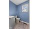 Bathroom with a white toilet, vanity, blue walls and window for great natural light at 2501 Reformers Ave, Indianapolis, IN 46203
