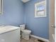 Bathroom with a white toilet, vanity, blue walls and window for great natural light at 2501 Reformers Ave, Indianapolis, IN 46203