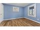 A well-lit bedroom featuring wood-style flooring and ample natural light from the window with white trim at 2501 Reformers Ave, Indianapolis, IN 46203