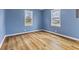 Bright bedroom with two windows allowing for natural light and wood-style flooring, creating a cozy atmosphere at 2501 Reformers Ave, Indianapolis, IN 46203