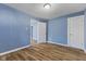 This bedroom features stylish wood flooring and a fresh coat of blue paint, offering a comfortable space at 2501 Reformers Ave, Indianapolis, IN 46203