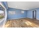 Spacious living room with a modern blue palette, wood-style flooring, and an abundance of natural light at 2501 Reformers Ave, Indianapolis, IN 46203