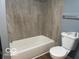 Bathroom with a white bathtub and beige tile surround at 3014 Arbor Ave, Indianapolis, IN 46217