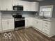 Well-lit kitchen with stainless steel appliances and white cabinets at 3014 Arbor Ave, Indianapolis, IN 46217