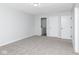 A simple bedroom featuring gray walls and plush carpet, with an ensuite laundry area at 3153 Stillmeadow Dr, Indianapolis, IN 46214
