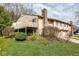 Multi-level home with stone chimney, an upper deck, and attached garages, surrounded by green landscaping and a grassy lawn at 3153 Stillmeadow Dr, Indianapolis, IN 46214