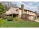 Tan home featuring a stone chimney, wood balcony and front yard in a quiet neighborhood at 3153 Stillmeadow Dr, Indianapolis, IN 46214
