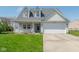 Charming two-story home with a cozy front porch and a well-maintained lawn, featuring a two-car garage at 329 Dogwood Dr, Pendleton, IN 46064
