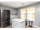 Updated kitchen boasts gray cabinets, center island, and modern stainless steel refrigerator at 329 Dogwood Dr, Pendleton, IN 46064