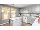 Charming kitchen features grey cabinets, a center island, and bright natural light at 329 Dogwood Dr, Pendleton, IN 46064