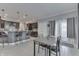Open dining area with gray walls, modern light fixtures, tile flooring, and view into kitchen with breakfast bar at 34 David Ln, Indianapolis, IN 46227