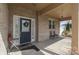 Inviting covered brick front porch with a decorative front door, welcome mat, and cozy seating area at 34 David Ln, Indianapolis, IN 46227
