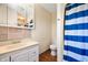Bathroom with vanity sink, mirror, toilet, and a shower with a blue and white shower curtain at 4411 W Friar Dr, Muncie, IN 47304
