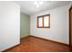 Bedroom featuring hardwood floors, light green accent wall, and window with wood trim at 4411 W Friar Dr, Muncie, IN 47304