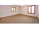 Empty bedroom with neutral carpeting, two windows, base molding and white walls at 4411 W Friar Dr, Muncie, IN 47304