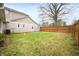 Fenced backyard features a well-maintained lawn, privacy, and mature trees at 453 S High School Rd, Indianapolis, IN 46241