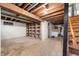 Spacious unfinished basement with wooden beams, storage shelves, and access to stairs at 453 S High School Rd, Indianapolis, IN 46241
