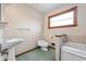 Cozy bathroom offers a vintage sink, toilet, and bathtub with natural light from a window at 453 S High School Rd, Indianapolis, IN 46241