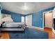 Cozy bedroom with blue wallpaper, hardwood floors, a king bed, and natural light at 453 S High School Rd, Indianapolis, IN 46241
