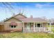 Charming stone home with a covered front porch featuring awning and manicured lawn at 453 S High School Rd, Indianapolis, IN 46241