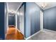 Bright hallway featuring wood floors and blue walls, illuminated by an elegant chandelier at 453 S High School Rd, Indianapolis, IN 46241