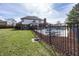 Well-maintained backyard featuring a pool, lush lawn, and patio area enclosed by a black fence, great for outdoor enjoyment at 4644 S Grassy Ct, New Palestine, IN 46163
