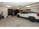 Well-organized garage with epoxy floors, storage cabinets and a white SUV parked inside, creating a functional space at 4644 S Grassy Ct, New Palestine, IN 46163