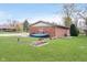 Backyard with lush lawn, garden beds, and a brick house with ample yard space at 5061 Sylvan Rd, Indianapolis, IN 46228