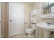 Bathroom featuring a toilet, sink, and shelving for storage at 5061 Sylvan Rd, Indianapolis, IN 46228