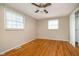 Bright bedroom featuring hardwood floors and two windows, creating an airy atmosphere at 5061 Sylvan Rd, Indianapolis, IN 46228