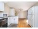 Open kitchen layout with white cabinetry, countertops, and seamless flow into living area with hardwood floors at 5061 Sylvan Rd, Indianapolis, IN 46228