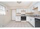 Bright kitchen featuring white cabinets, neutral countertops, and tiled floors at 5061 Sylvan Rd, Indianapolis, IN 46228