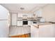 Bright kitchen featuring ample white cabinetry and tiled flooring, adjacent to the living area at 5061 Sylvan Rd, Indianapolis, IN 46228
