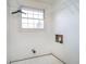 Laundry room with white walls, window for natural light, and tiled floors at 5061 Sylvan Rd, Indianapolis, IN 46228