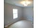 Carpeted bedroom featuring neutral paint, a window, and a modern light fixture at 5523 Epperson Ct, Indianapolis, IN 46221