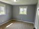 A standard bedroom painted gray, featuring carpet and two windows at 5630 S Cladwell Dr, Pendleton, IN 46064