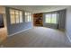 Bright living room featuring a brick fireplace, carpet flooring, and large windows at 5630 S Cladwell Dr, Pendleton, IN 46064