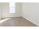 An empty bedroom with neutral walls, light wood flooring and a window at 5653 Stetson Dr, Whitestown, IN 46052