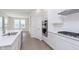 Bright kitchen features stainless steel appliances, white cabinetry and backsplash, and durable wood-look floors at 5653 Stetson Dr, Whitestown, IN 46052