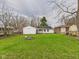 Spacious backyard featuring a lawn, garage, and residential fencing at 612 Woodlawn Dr, Anderson, IN 46012