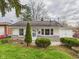 Single-story home with a well-maintained lawn, mature shrubs, and an attached garage at 612 Woodlawn Dr, Anderson, IN 46012