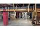 Spacious unfinished basement with exposed pipes, painted support beams, and ample storage at 6141 Madison Ave, Indianapolis, IN 46227