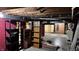 Unfinished basement with exposed wood beams, painted brick, and shelving at 6141 Madison Ave, Indianapolis, IN 46227