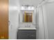 Bathroom with gray vanity, updated lighting, and shower with curtain at 6141 Madison Ave, Indianapolis, IN 46227