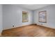Bright bedroom with hardwood floors, two windows, and neutral paint, offering a versatile space at 6141 Madison Ave, Indianapolis, IN 46227