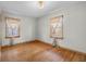 Bedroom with hardwood floors, neutral walls, and natural light from two windows at 6141 Madison Ave, Indianapolis, IN 46227